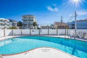 una piscina con una valla y un edificio en Waterfront Condo Carolina Beach en Carolina Beach