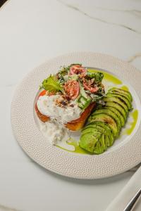 a plate of food with a sandwich and vegetables at Modern Art Hotel - Maestro in Lviv +62 photos