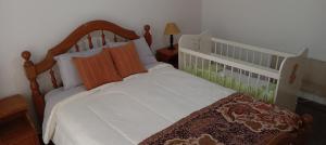 a bedroom with a white bed with a wooden headboard at Sueños del Pilar in Godoy Cruz