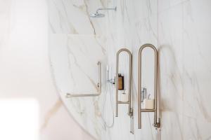 a bathroom with white marble walls and brass towel racks at Hotel Málaga Vibes in Málaga