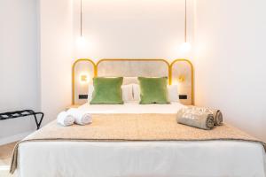 a bedroom with a large bed with green pillows at Hotel Málaga Vibes in Málaga