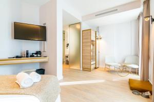 a hotel room with a bedroom with a bed and a tv at Hotel Málaga Vibes in Málaga