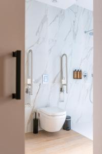 a white bathroom with a toilet and a sink at Hotel Málaga Vibes in Málaga