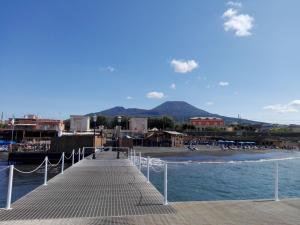 a pier with a beach and buildings and the ocean at Cliò guest house in Ercolano