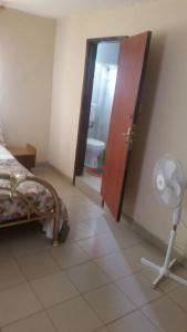 ein Schlafzimmer mit einem Bett und einem Ventilator sowie ein Badezimmer in der Unterkunft #5 princess apartments, 230mt to senegambia business strip, Wes coast GMbia in Sere Kunda