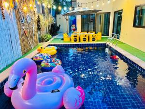 a swimming pool with two inflatable toys in it at Dream pool villa1 in Sattahip