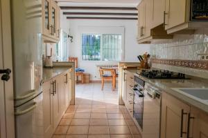 a kitchen with white cabinets and a stove top oven at Villa La Paz in El Tosalet