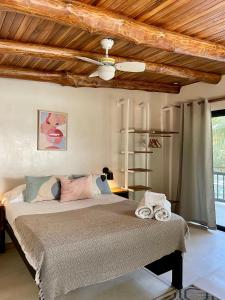 een slaapkamer met een bed en een houten plafond bij Believe Surf & Yoga Lodge Santa Teresa in Santa Teresa Beach