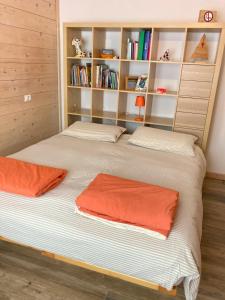 1 dormitorio con 2 camas y estante para libros en Pedibosco Orange en Calalzo