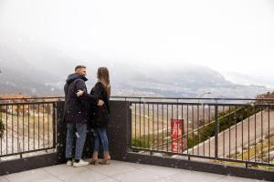 un hombre y una mujer de pie en la cima de una montaña en Hotel Alt Spaur, en Spormaggiore