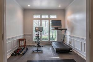 a room with a gym with a treadmill and a tv at Sleeps 14 - Pinehurst in Pinehurst