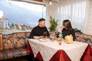 un homme et une femme assis à une table dans un restaurant dans l'établissement Hotel Alt Spaur, à Spormaggiore