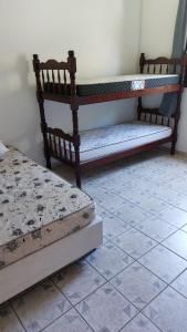 two beds sitting next to each other in a room at Maury Chalés Boiçucanga in São Sebastião