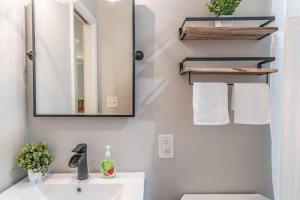 a bathroom with a sink and a mirror and towels at Maine Avenue- Downtown Southern Pines in Southern Pines +16 photos