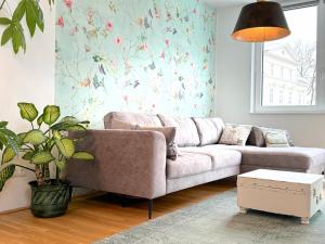ein Wohnzimmer mit einem Sofa und einer Pflanze in der Unterkunft Traunseeresidenzen in Gmunden