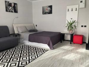 1 dormitorio con 1 cama y 1 maleta roja en Apartments on Gagarina, en Vínnytsia
