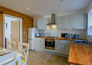 a kitchen with white appliances and a wooden table at No 6 Deer Glade 