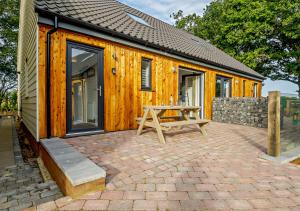 a wooden cabin with a picnic table in front of it at No 6 Deer Glade in Sparham