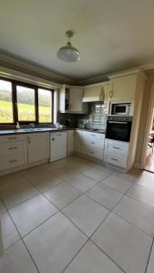 a large kitchen with white cabinets and appliances at BARR AN CHNOIC HOLIDAY LETTINGS in Tipperary