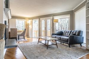uma sala de estar com um sofá e uma mesa em Sleeps 6- Whispering Pines Lakefront 