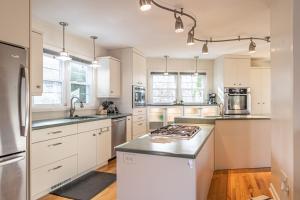 a kitchen with white cabinets and stainless steel appliances at Sleeps 6- Whispering Pines Lakefront 