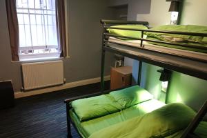 a room with three bunk beds and a window at YHA Helvellyn in Glenridding