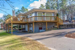 a large house with a deck on a street at Sleeps 6- Whispering Pines Lakefront 