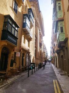 un vicolo con edifici e una persona che cammina per la strada di Tal-Munfuha- Centrally Located Space. a La Valletta