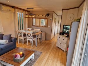 a living room with a couch and a table at Chalet voorzien van alle gemakken in een bosrijke omgeving in Voorthuizen