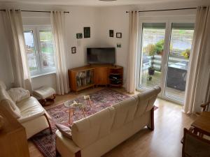 a living room with a couch and a television at Ferienwohnung „Lena“ in Meißen