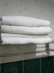 una pila de toallas blancas sentadas en un estante en 3 BEDROOM SEAVIEW CONDO @ GLORY BEACH RESORT, PORT DICKSON en Port Dickson