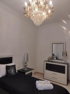 a bedroom with a bed and a mirror and a chandelier at Tal-Munfuha- Centrally Located Space. in Valletta