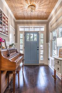 a room with a piano and a blue door at Sleeps 8-Whispering Pines 