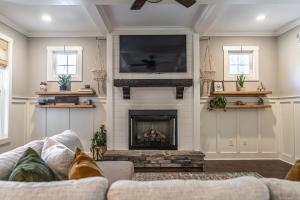a living room with a fireplace and a tv at Sleeps 8-Whispering Pines 