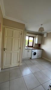 an empty kitchen with a door and a window at BARR AN CHNOIC HOLIDAY LETTINGS in Tipperary