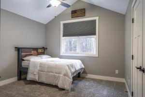 1 dormitorio con cama y ventana en Sleeps 8-Whispering Pines 