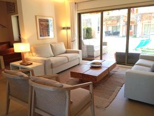 ein Wohnzimmer mit einem Sofa und einem Tisch in der Unterkunft Anis Lux Tavira Residence Villa 5Q in Luz de Tavira