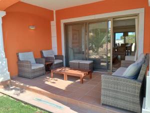 patio z wiklinowymi krzesłami i stolikiem kawowym w obiekcie Anis Lux Tavira Residence Villa 5Q w mieście Luz de Tavira