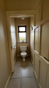 a small bathroom with a toilet and a window at BARR AN CHNOIC HOLIDAY LETTINGS in Tipperary