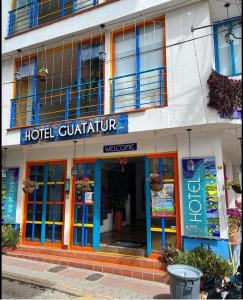 een hotelquattro met een bord aan de voorzijde van een gebouw bij Hotel Guatatur in Guatapé