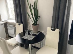 comedor con mesa negra y sillas blancas en Apartments on Gagarina, en Vínnytsia