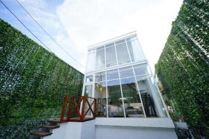 a small house with a large window in between two tall hedges at ⁂ビーチからすぐ！開放的な一軒家で家族や友人と湘南を満喫！新江ノ島水族館まで徒歩で約6分⁂ in Katase