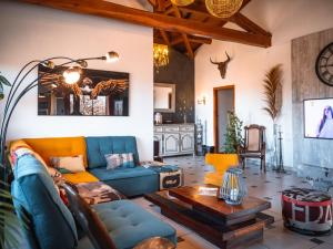 sala de estar con sofá azul y mesa en Villa Magarre Climatisée, Piscine Chauffée, Spa, dans un Cadre Naturel Envoûtant, en Castelnau-de-Montmiral