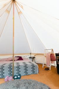 Glamping in Småland في إيكشو: غرفة نوم بسرير وخيمة