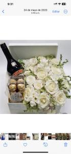 a box filled with white roses and a bottle of beer at Y Beautiful and comfortable in Moca