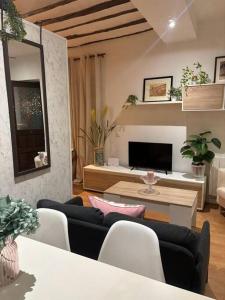 ein Wohnzimmer mit 2 Sofas und einem TV in der Unterkunft Estudio Herrero in Alcalá de Henares