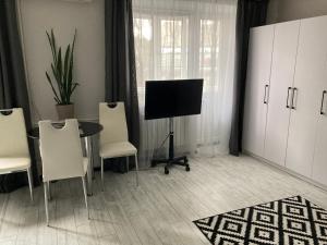 sala de estar con mesa, sillas y TV en Apartments on Gagarina, en Vínnytsia