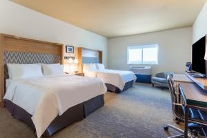 een hotelkamer met 2 bedden en een bureau bij Holiday Inn & Suites Cedar Falls-Waterloo Event Ctr, an IHG Hotel in Cedar Falls