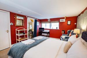 a bedroom with a white bed and red walls at Cosy Stable at Oak Farm in Usk