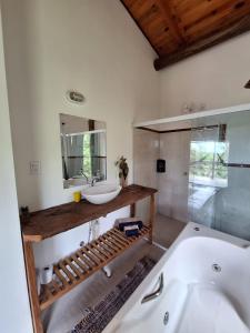 a bathroom with a sink and a mirror and a tub at Chalé dos Altos de Laranjeiras in Paraty +32 photos